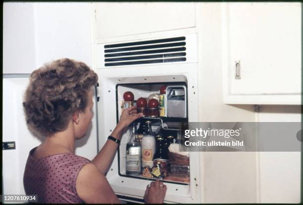 Hausfrau in der Küche am Kühlschrank