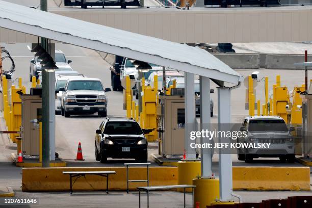 Vehicles cross at the US Customs booth at the Ambassador Bridge that connects Windsor, Canada, to Detroit, Michigan on March 18, 2020 in Detroit,...