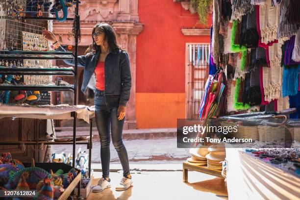 young woman shopping for jewlery along historic street - mexican street market stock pictures, royalty-free photos & images