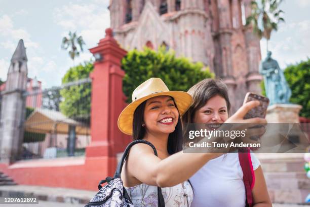 young women taking selfie in historic town square - fotoberichten stockfoto's en -beelden