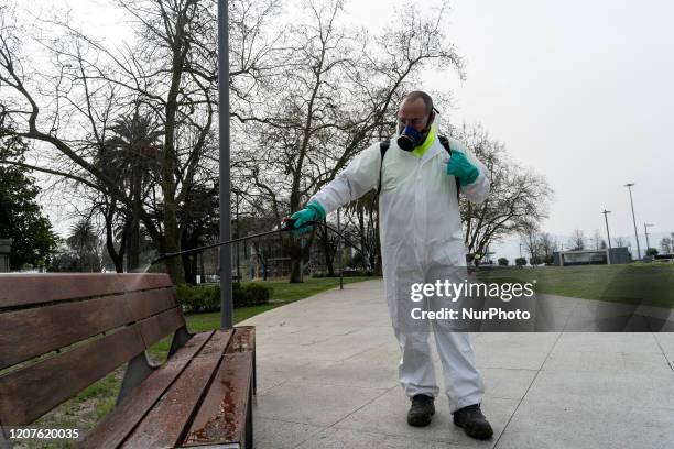 Municipal employee performs his cleaning and disinfection work in banks and other urban furniture in the city of Santander, Spain on March 18, 2020...