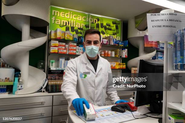 An employee of a pharmacy carries out his work in the city of Santander, Spain on March 18, 2020 complying with the safety and hygiene protocols for...