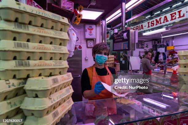 The employee of a butcher shop in the central market performs her work in the city of Santander, Spain on March 18, 2020 complying with the safety...