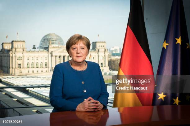 In this handout photo provided by the German Government Press Office , German Chancellor Angela Merkel addresses the nation via a video statement...