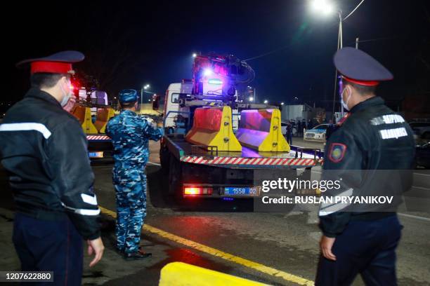 Kazakh police set up a road block at an entrance to the city of Almaty on March 19, 2020. - Kazakhstan's two largest cities will go on lockdown from...