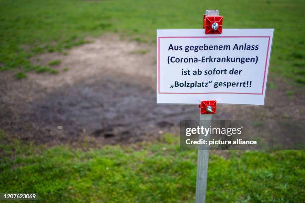 March 2020, Bavaria, Oberhaid: On a soccer field in Oberhaid a sign with the inscription "For given reason the "Bolzplatz" is closed from now on!...