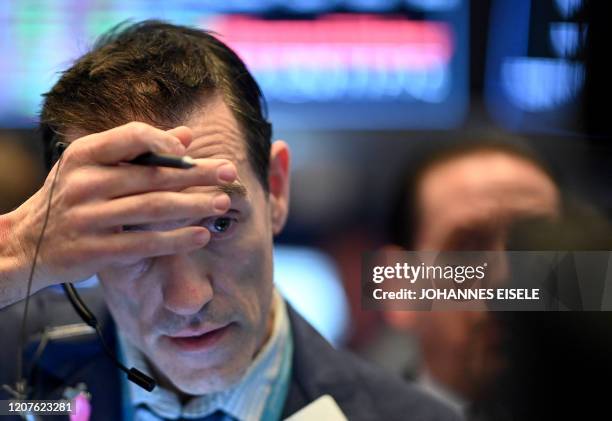 Traders work during the closing bell at the New York Stock Exchange on March 18, 2020 at Wall Street in New York City. Wall Street stocks plunged...