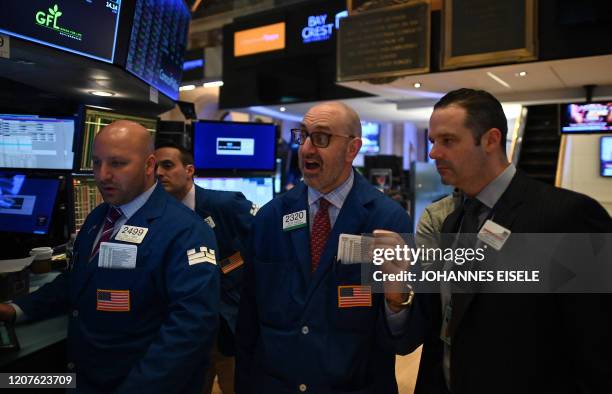 Traders work during the closing bell at the New York Stock Exchange on March 18, 2020 at Wall Street in New York City. Wall Street stocks plunged...