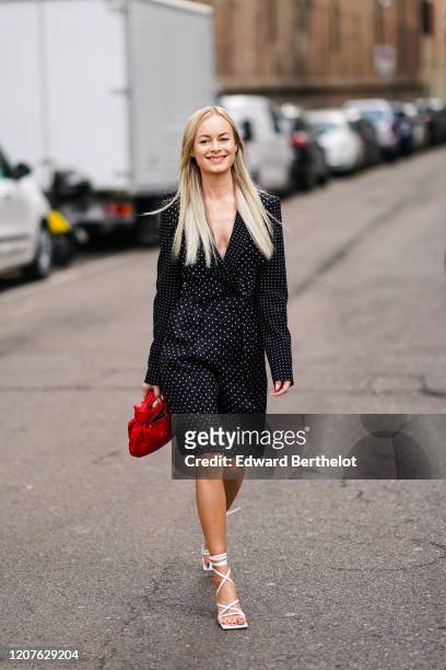 Thora Valdmirars wears a low-neck dress with printed polka dots, a red bag, outside Max Mara, during Milan Fashion Week Fall/Winter 2020-2021 on...