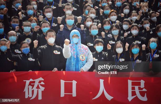 Members of a medical assistance team from Jiangsu province chant slogans at a ceremony marking their departure after helping with the COVID-19...