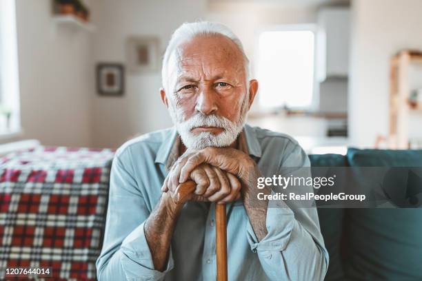 hombre mayor sentado solo en casa - sad old man fotografías e imágenes de stock