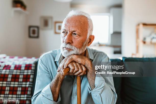 älterer mann sitzt allein zu hause - real people serious not looking at camera not skiny stock-fotos und bilder