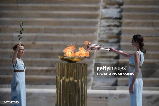 Greek actress Xanthi Georgiou dressed as an ancient Greek high priestess lights the olympic torch during the olympic flame handover ceremony for the...