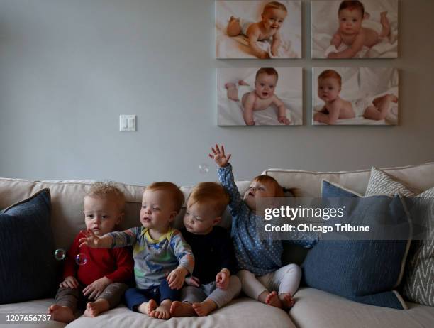 Desde la izquierda, Oliver Randall, JP, Bobby y Arden Whitmer, de 1 año de edad, se acercan a las burbujas que crea su niñera en la casa de la...