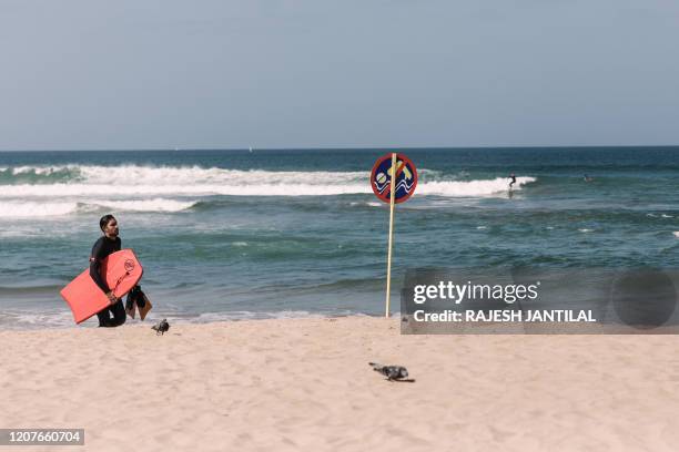 Picture taken on March 19, 2020 shows a bodyboarder at the north beach in Durban as the eThekwini Municipality places drastic measures to be imposed...
