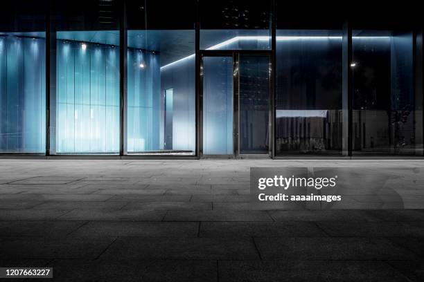 empty road with modern building's window - city by night stock-fotos und bilder