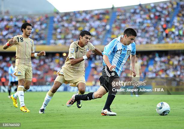 Adrian Martinez of Argentina runs for the ball with Aly Fathy of Egypt during the FIFA U-20 World Cup Colombia 2011 round of 16 match between...
