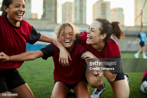 striker celebrates a goal with her team mates. - soccer team stock pictures, royalty-free photos & images