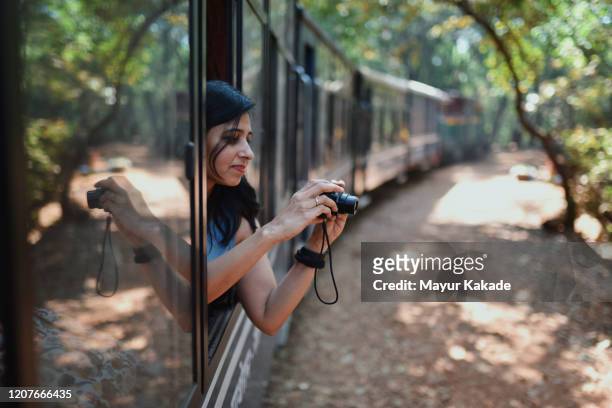 woman travelling by tourist train - india train stock-fotos und bilder
