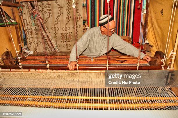 Man weaving a carpet on a loom using Agave silk in Chefchaouen, Morocco, Africa on December 29, 2015.