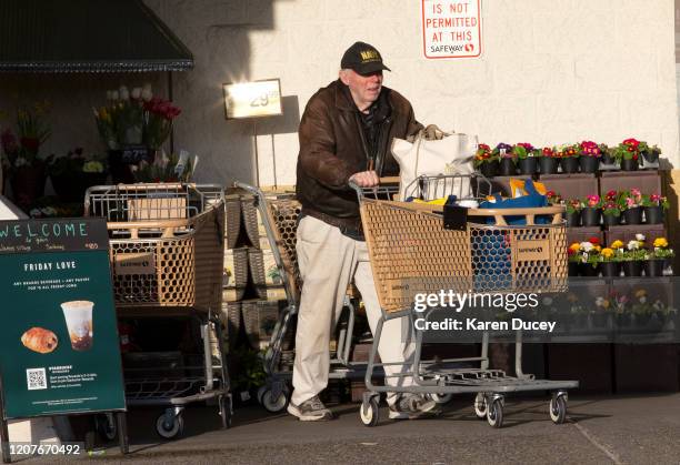 Paul Henderson from Lynnwood, WA leaves a Safeway grocery store early in the morning on March 19, 2020 in Lynnwood, Washington. He was there taking...