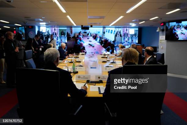 President Donald Trump, right, and Vice President Mike Pence attend a teleconference with governors at the Federal Emergency Management Agency...