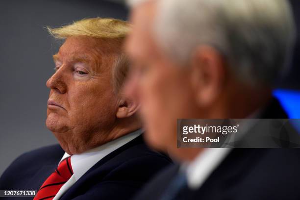 President Donald Trump listens during a teleconference with governors at the Federal Emergency Management Agency headquarters, Vice President Mike...
