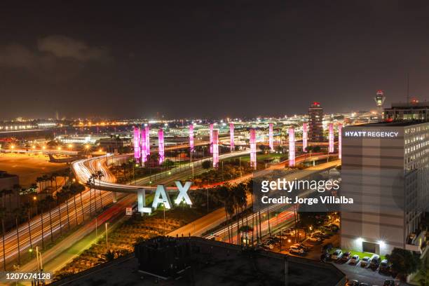 lax los angeles international airport sign und pylonen bei nacht - lax stock-fotos und bilder
