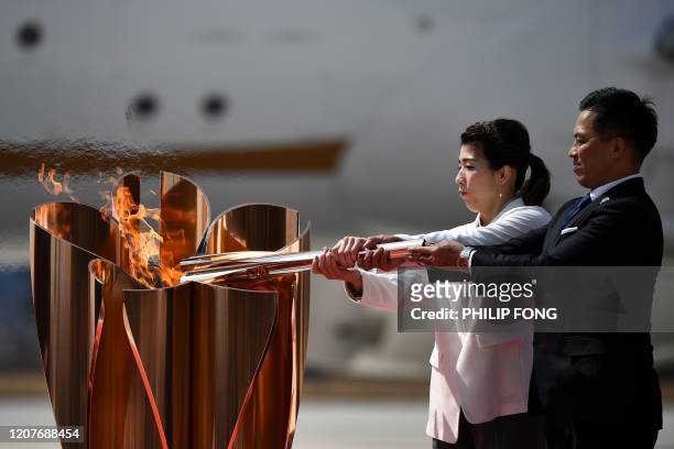 Japanese three-time Olympic gold medallists Saori Yoshida and Tadahiro Nomura light a Tokyo 2020 Olympic cauldron with the Olympic flame, after...