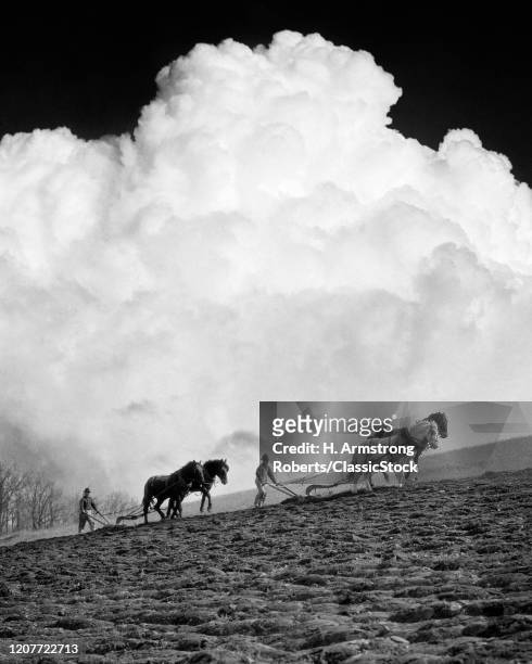 1920s 1930s 1940s two anonymous silhouetted farmers each behind a two horse team plowing a field to prepare for spring planting.