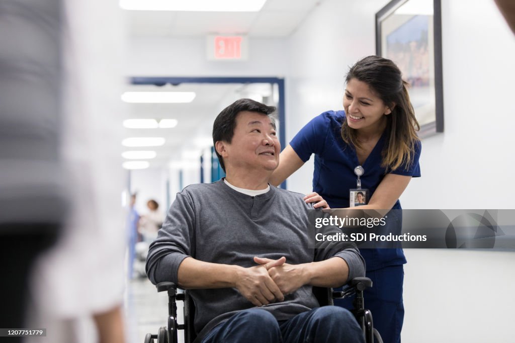 Cheerful nurse talks with senior patient