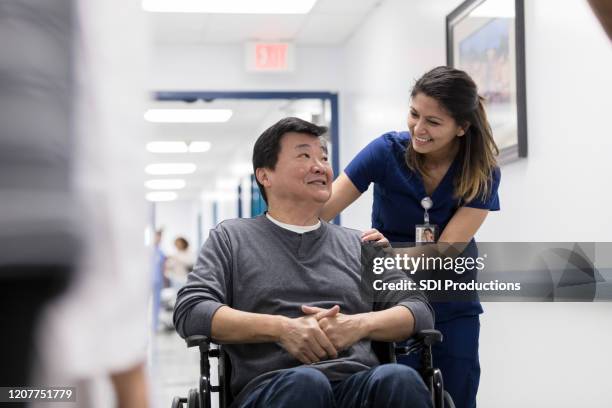 cheerful nurse talks with senior patient - urgent care stock pictures, royalty-free photos & images