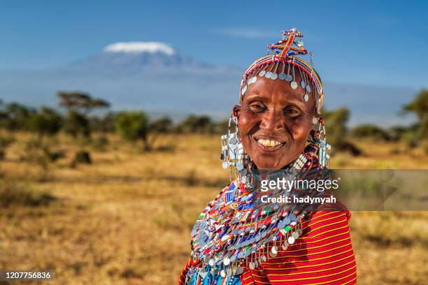 retrato de la mujer africana feliz, monte kilimanjaro en el fondo, kenia, africa oriental - a beautiful masai woman fotografías e imágenes de stock