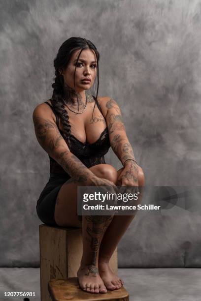 Portrait of tattoo artist Tatu Baby as she sits on a wooden box, New York, New York, July 20, 2019.