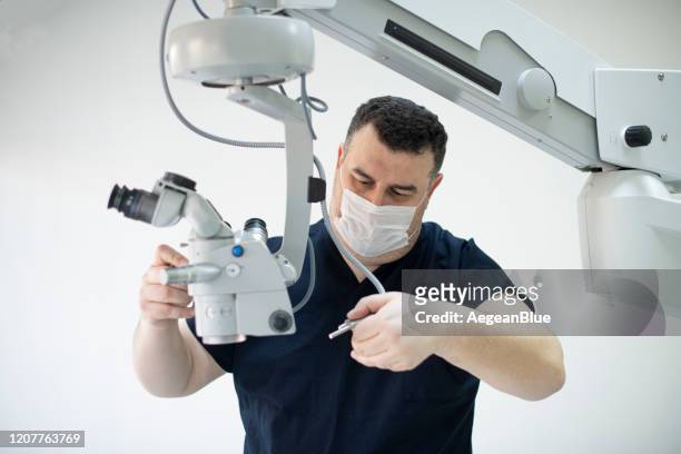 técnico reparando un microscopio operativo - medical equipment fotografías e imágenes de stock