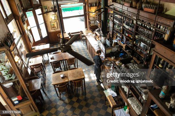 camarera preparando las cosas antes del comienzo de la jornada laboral en la cafetería tradicional de buenos aires - bar cafeteria fotografías e imágenes de stock