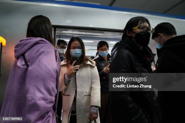 Commuters wear protective masks as they exit a train at subway on March 20, 2020 in Beijing, China. Since the new coronavirus covid-19 first emerged...