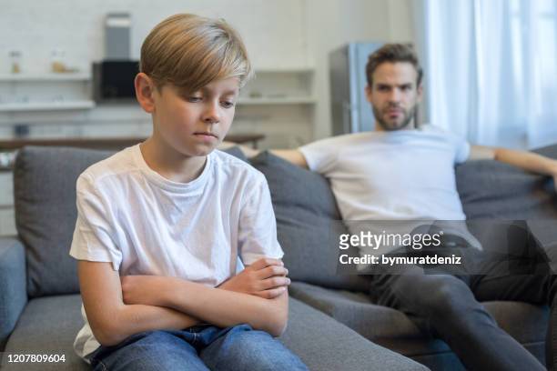 sad and bored child at home couch feeling frustrated - strict parent imagens e fotografias de stock