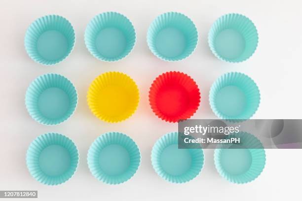 light blue, yellow and red silicone ramekins, top view - muffin top stock-fotos und bilder