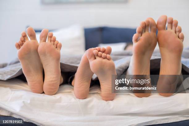 feet of a family sticking out from the white blanket - teen boy barefoot stock pictures, royalty-free photos & images