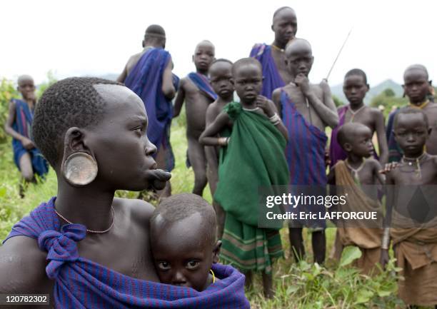 Surma woman and kids in Kibbish village, Omo valley, Ethiopia on July 04, 2010 - Piercing and lip plates are a strong part of the Suri culture. These...