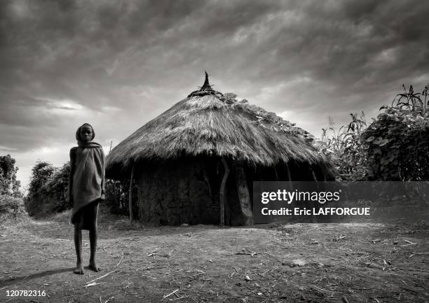 Surma boy in front of a hut in Turgit village, Omo valley, Ethiopia on July 04, 2010 - Surma or Suri are sedentary pastoral people living in south...