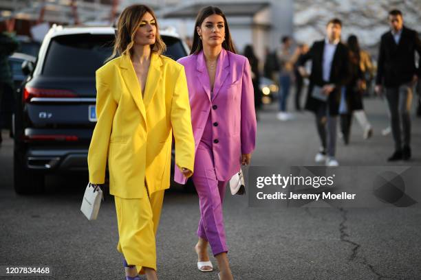 Angela Rozas Saiz wearing a yellow suit and Aida Domenech wearing a purple suit are seen during Milan Fashion Week Fall/Winter 2020-2021 on February...