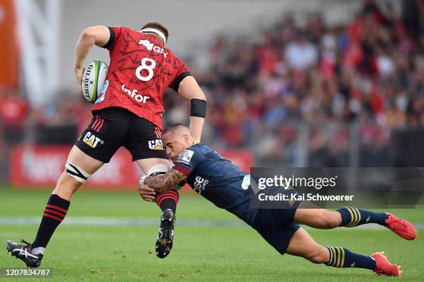 Aaron Smith of the Highlanders tackles Tom Sanders of the Crusaders during the round four Super Rugby match between the Crusaders and Highlanders at...