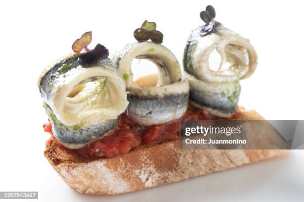 canape de anchoas blancas (boquerones o boquerones en vinagre) elaborados con pan baguette en rodajas tostados y salsa de tomate - anchovy fotografías e imágenes de stock