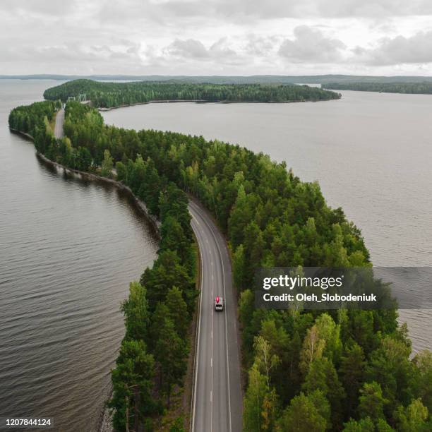 scenic aerial view of camper van with canoe on roof on road through the lake in finland lakeland - finland forest stock pictures, royalty-free photos & images