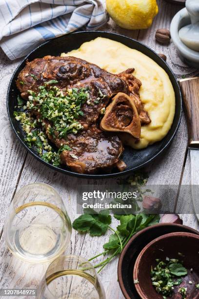 ossobuco topping with gremolata,   served with polenta - osso bucco stock-fotos und bilder