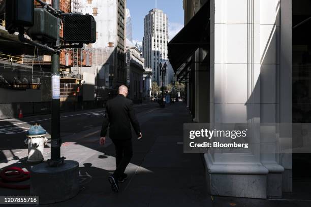 Pedestrian walks along a near empty street in downtown San Francisco, California, U.S., on Friday, March 20, 2020. California Governor Gavin Newsom...