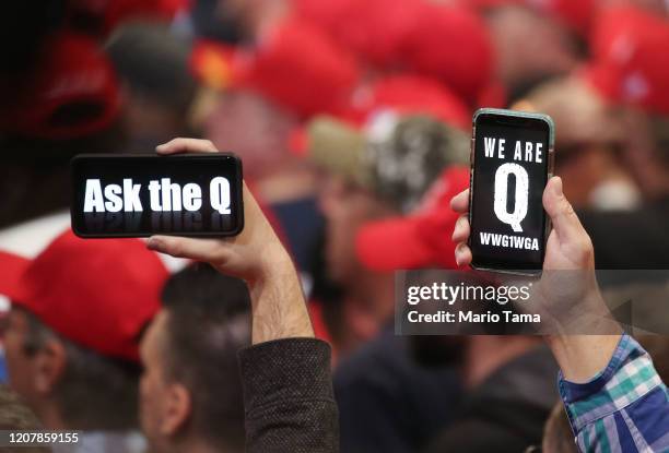 Supporters of President Donald Trump hold up their phones with messages referring to the QAnon conspiracy theory at a campaign rally at Las Vegas...