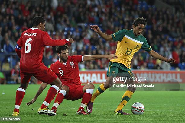 Adam Sarota of Australia challenged by Joe Ledley during the International Friendly match between Wales and Australia at the Cardiff City Stadium on...